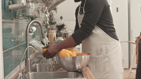 Man Washing Fresh Bell Peppers alt