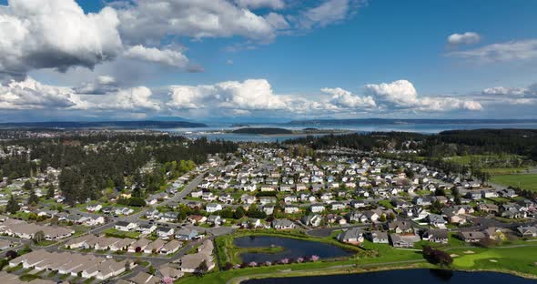Wide aerial shot pulling away from Oak Harbor's vast sea of suburban homes on Whidbey Island. alt