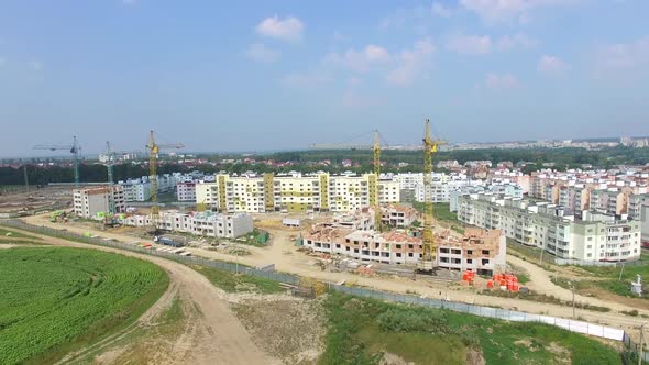 modern high-rise buildings are building on the outskirts of the city in the summer. Aerial view alt