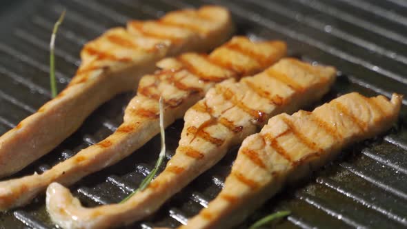 Piece of Salmon or Trout Fillet Frying on Grilled Pan. alt