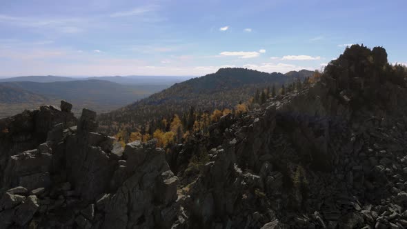 Aerial view of the mountains with rocks and beautiful autumn woods on the slopes alt