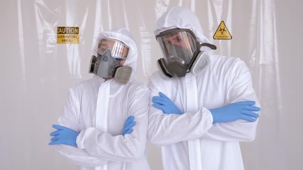 Two Doctors in Medical Protective Suits in a Hospital with Their Arms Crossed alt