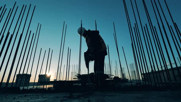 Male Constructor Is Using a Jackhammer To Demolish Concrete alt