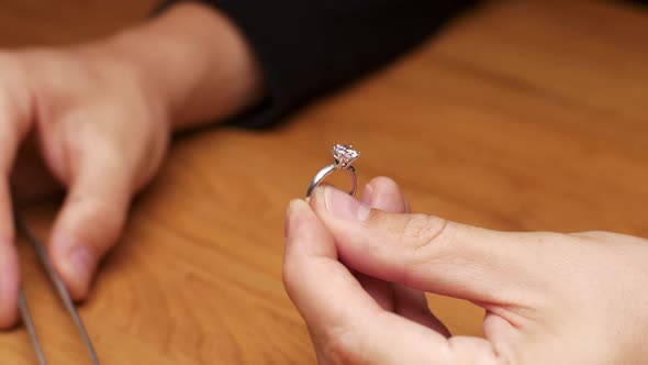 Close Up of Jeweler Inserts Diamond Into Ring