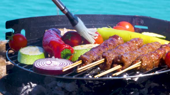 Grilling Kebabs With Vegetables On The Griil Plate, Turquoise Sea And Blu Sky On Background