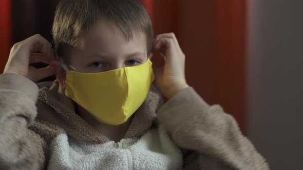 A Teenage Boy Wears a Yellow Protective Mask. Coronavirus Epidemic 2020.