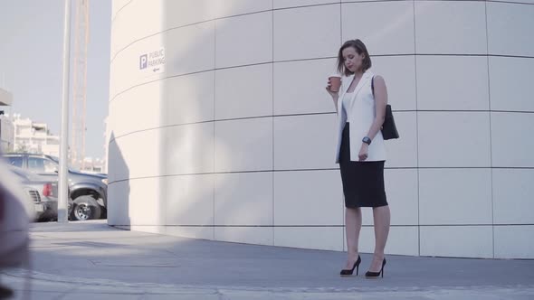 Businesswoman Drinking Coffee and Checking Smartwatch on Work Break Outdoors