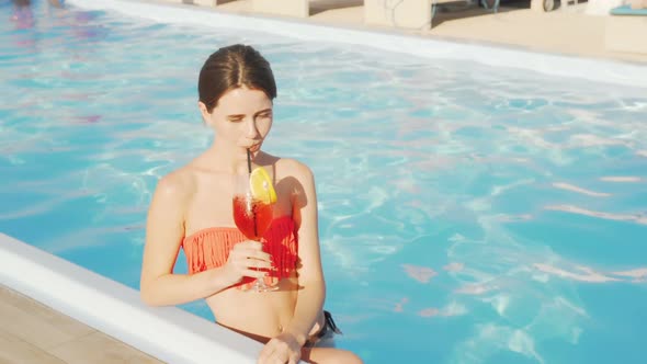 Gorgeous Woman Enjoying Cocktail at the Swimming Pool