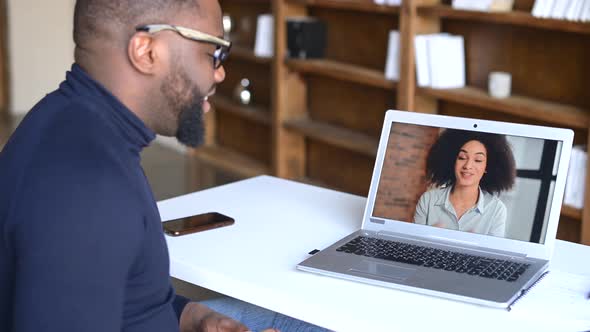 AfricanAmerican Man Making Video Call with His Female Friend or Coworker alt