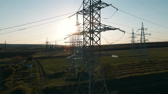 Aerial View of Electricity Pylons and High Voltage Power Line at Sunset alt