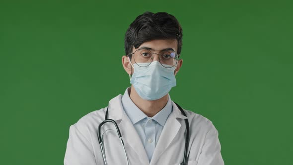 Portrait of Young Guy Doctor in Studio on Green Background Serious Hispanic Man in Protective alt