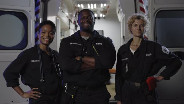 Multi Ethnic Paramedics Smiling on Camera Near Ambulance alt