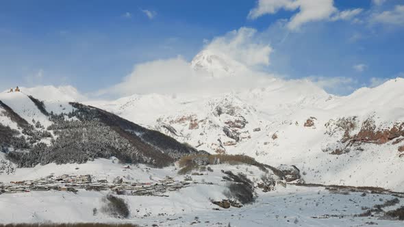 Mountain Valley in Kazbegi Region with Small Town Covered with Snow on Clear Day