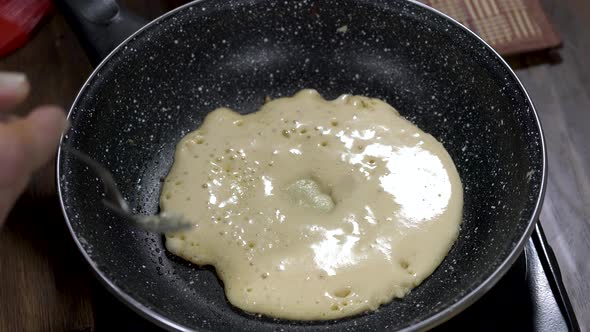 Cooking pancakes in a black pan