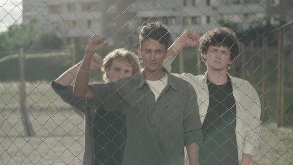 Three Serious Young Men Shaking Clenched Fists and Looking at Camera. Portrait of Group of alt