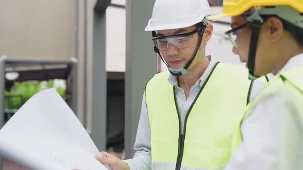 Asian colleague workers people wearing protective safety helmet and glasses onsite of architecture alt