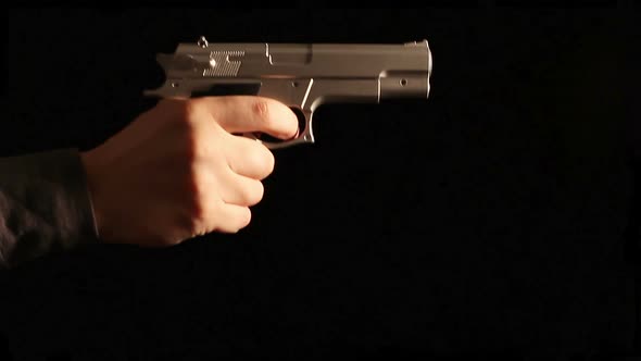 Man's hand with a gun appears on black background