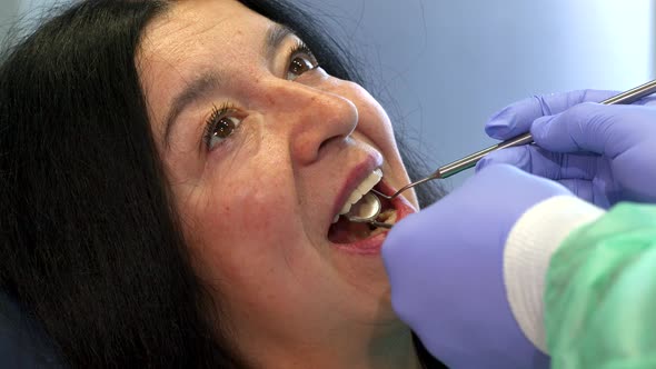 Dentist Holds Dental Instruments in Client's Mouth