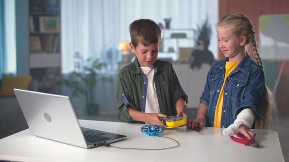 Children Entertainment Active Kids with Tools Go to the Table to Repair Mini Quadcopter That is alt