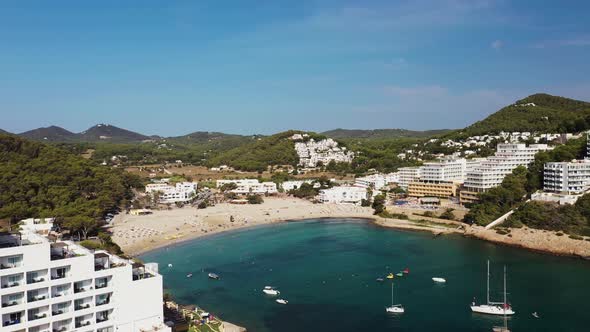 Aerial footage of the Spanish island of Ibiza showing the beautiful beach front alt