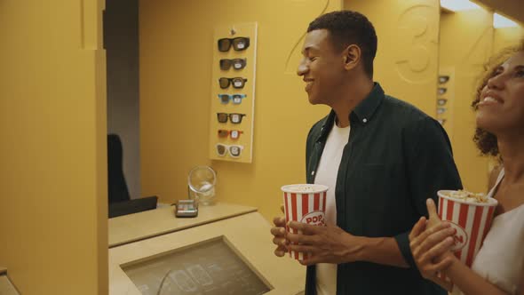 A Couple Buys Tickets at the Ticket Office in a Cinema alt