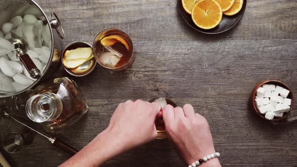 Step by step. Preparing Bourbon old fashioned cocktail at home bar. alt