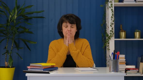 Religious Middle Aged Woman Sit with Eyes Closed Put Hands in Prayer Praying