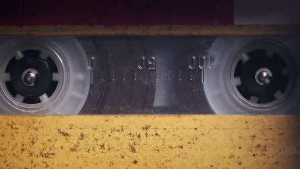 Vintage Yellow Audio Cassette Playing in Deck of an Old Tape Recorder alt