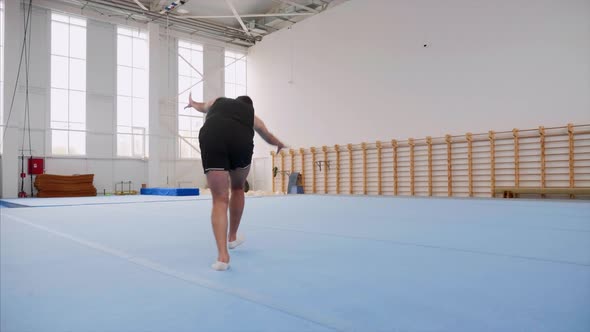 A Sportsman Is Doing a Cartwheel and a Double Back Flip and Lands, Steadicam. alt