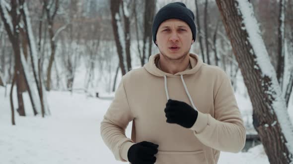 Man Breathing Out Steam While Jogging Outside in Winter alt