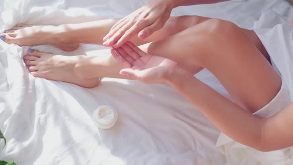 Women's Hands Lubricate Their Feet with Cream