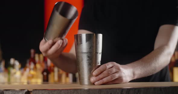 Bartender Shaker with Mixed Cocktail and Puts the Frozed Cocktail Glass to the Bar Counter Making alt