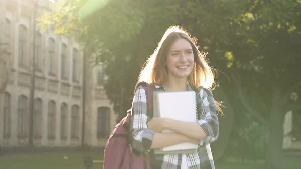 Attractive Young Woman Walking with Textbooks, Smiling and Enjoying Nice Day