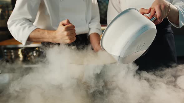 Professional kitchen: liquid nitrogen is added during the cooking of a molecular dish alt