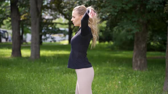 Young Woman Stretching in Park
