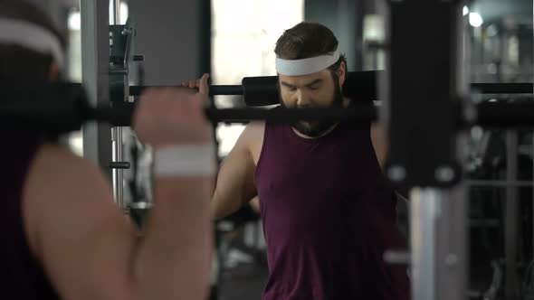 Obese Man Hardly Doing Exercise With Barbell in Gym, Fitness Workout, Sport alt