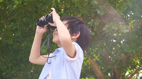Cute Asian Child Using Binocular On Summer Day alt