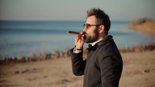 Relaxing Businessman In Sunglasses Smoke Cigar. Confident Well-Dressed Man Smoking. alt