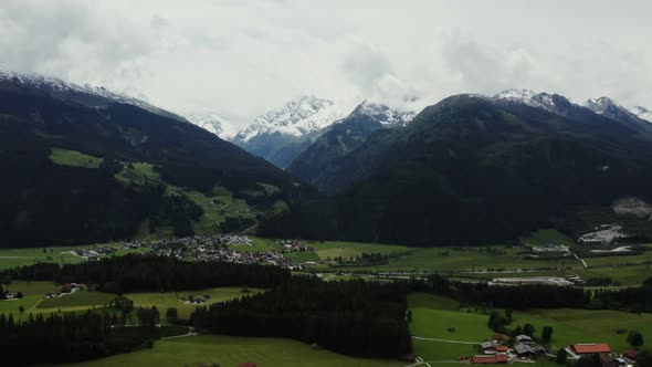 Panoramic View of a Picturesque Mountain Valley with a Village in a Lowland alt