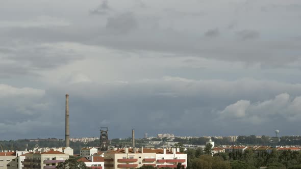White Clouds Moving Over Urban Buildings And Factory Chimney Stacks. - timelapse alt