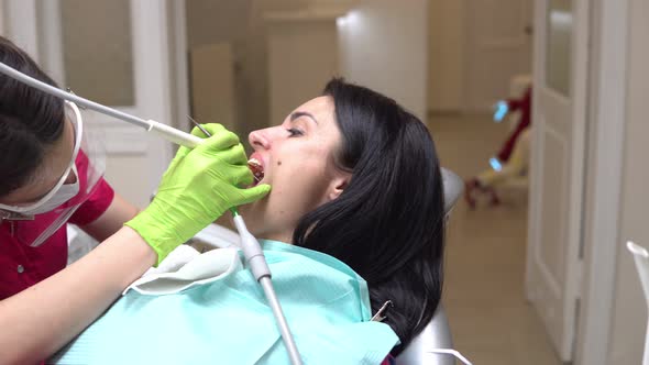Woman at the Dental Hygienist Getting Professional Tooth Whitening and Ultrasound Cleaning alt