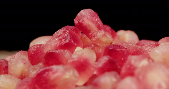 red pomegranate grains on table alt