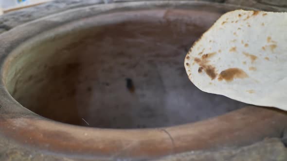 the Baker Takes Out the Armenian Lavash Baked in the Tandoor Tonir with His Hand