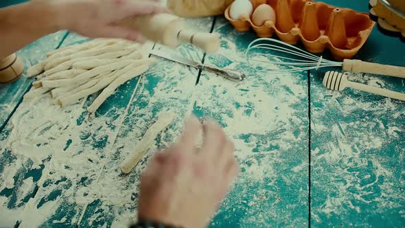 Baker Hands Preparing Fresh Dough with Rolling Pin on Kitchen Table. Man Forming the Dough on a alt