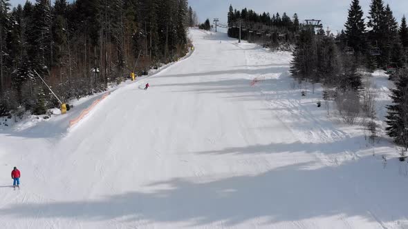 Aerial View of Skiers Go Down Ski Slopes Near Ski Lifts on Ski Resort. Bukovel alt