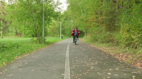 Cute Boy Bicyclist Riding on Bicycle in Summer Park alt