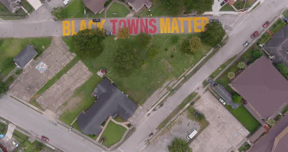 Bird eye view of a large "Black Towns Matter" sign painted on street in Houston Historical independe alt