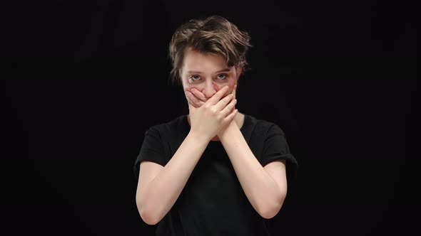Helpless Oppressed Young Woman with Bruises on Face and Mouth Closed with Hands Looking at Camera alt