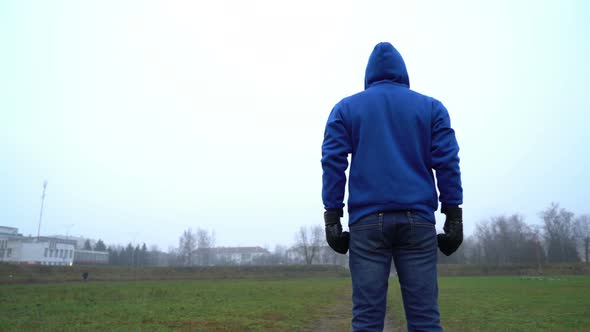 Loneliness Concept, Man Alone Standing Outdoors in Park, Rear View, Wearing Boxing Gloves, Fight