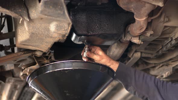 Changing The Old Oil Of The Car At The Repair Shop alt